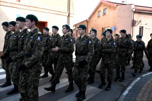 Grupa ludzi, maszerująca w mundurach