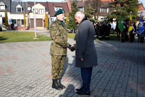 Mężczyzna w mundurze składa meldunek mężczyźnie w garniturze