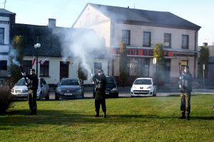 Trzech mężczyzn w mundurach, oddających salwę honorową poległym