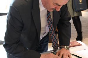 Mężczyzna, podpisujący się na liście