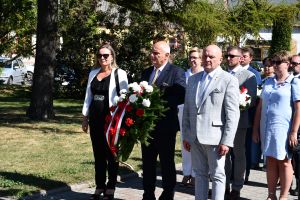Starosta radziejowski, skarbik i przewodniczący rady składają kwiaty przy pomniku